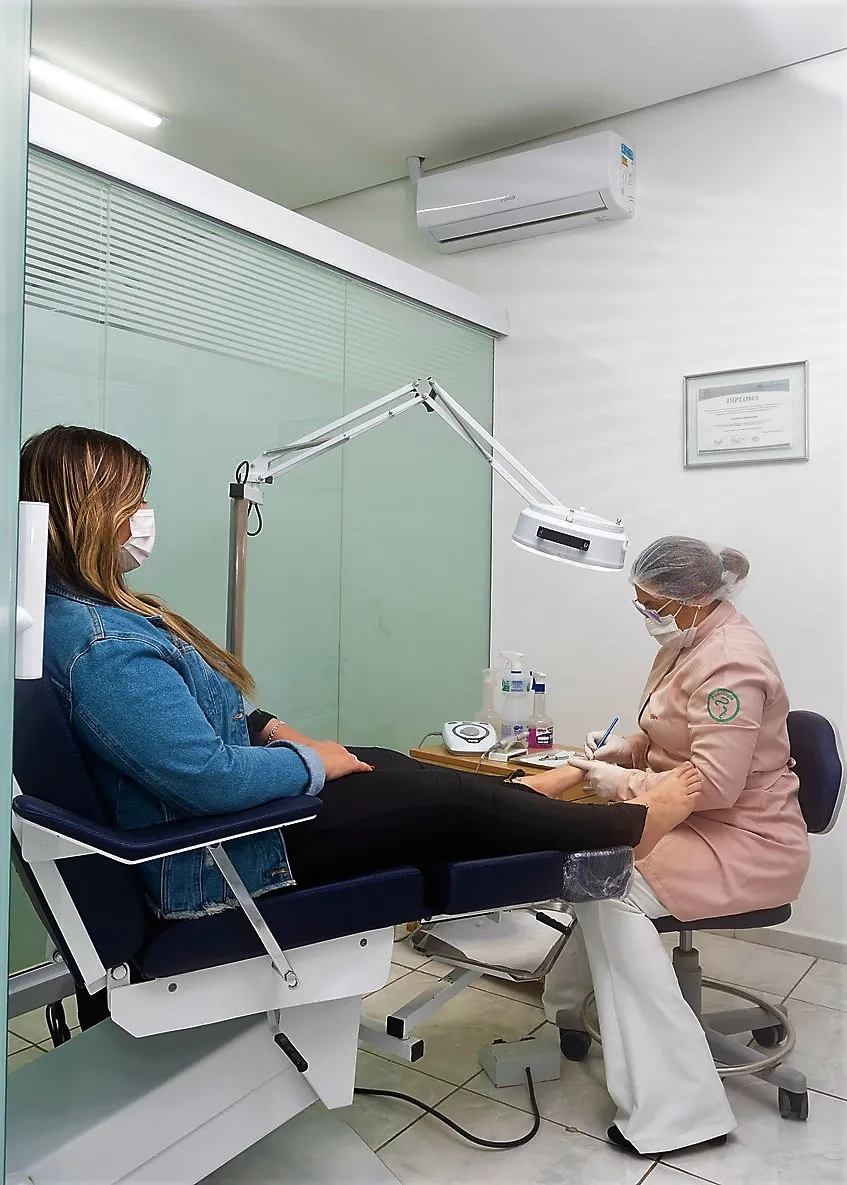 Sala de atendimento da Podologia ABC, com divisória de vidro, luz clínica, álcool em gel e diploma na parede